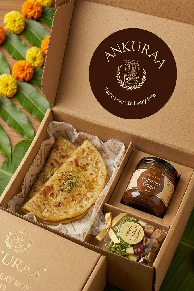 Open box containing Ugadi treat with Ankuraa branding, featuring a flatbread and other items on a decorative background.
